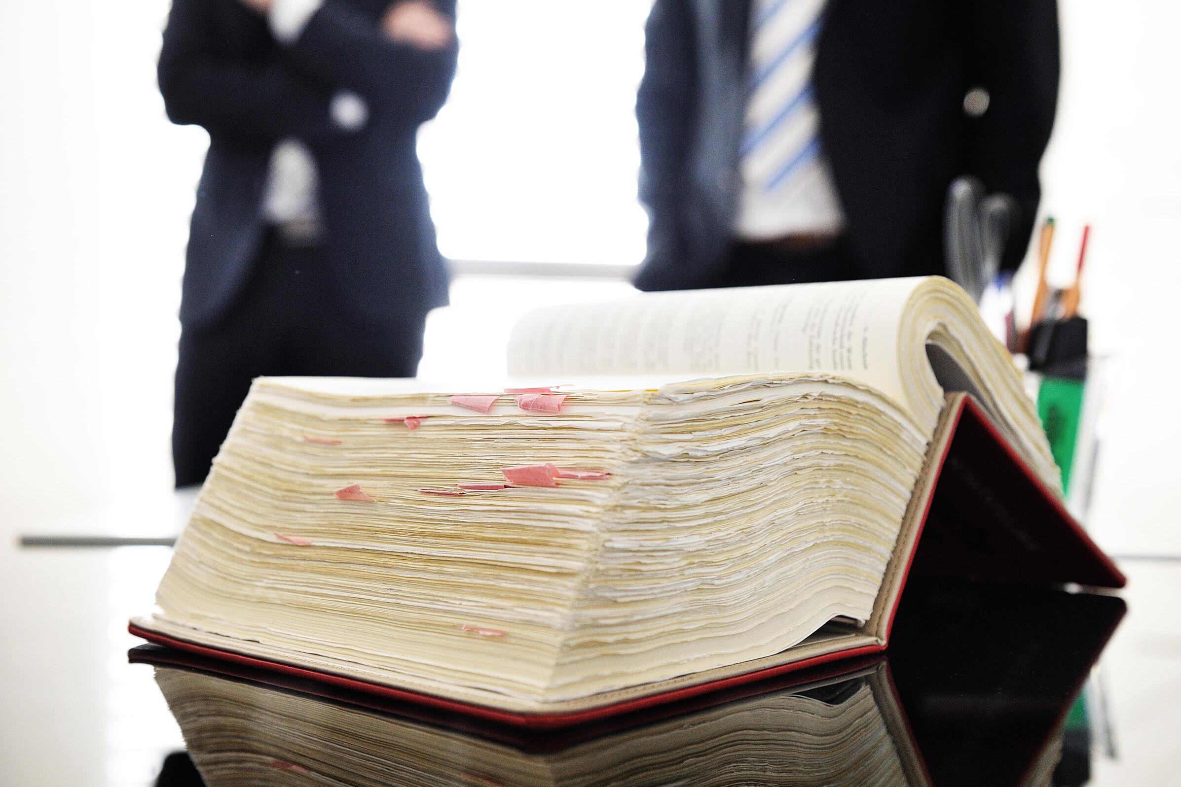 Dickes aufgeschlagenes Buch mit Markierungen darin