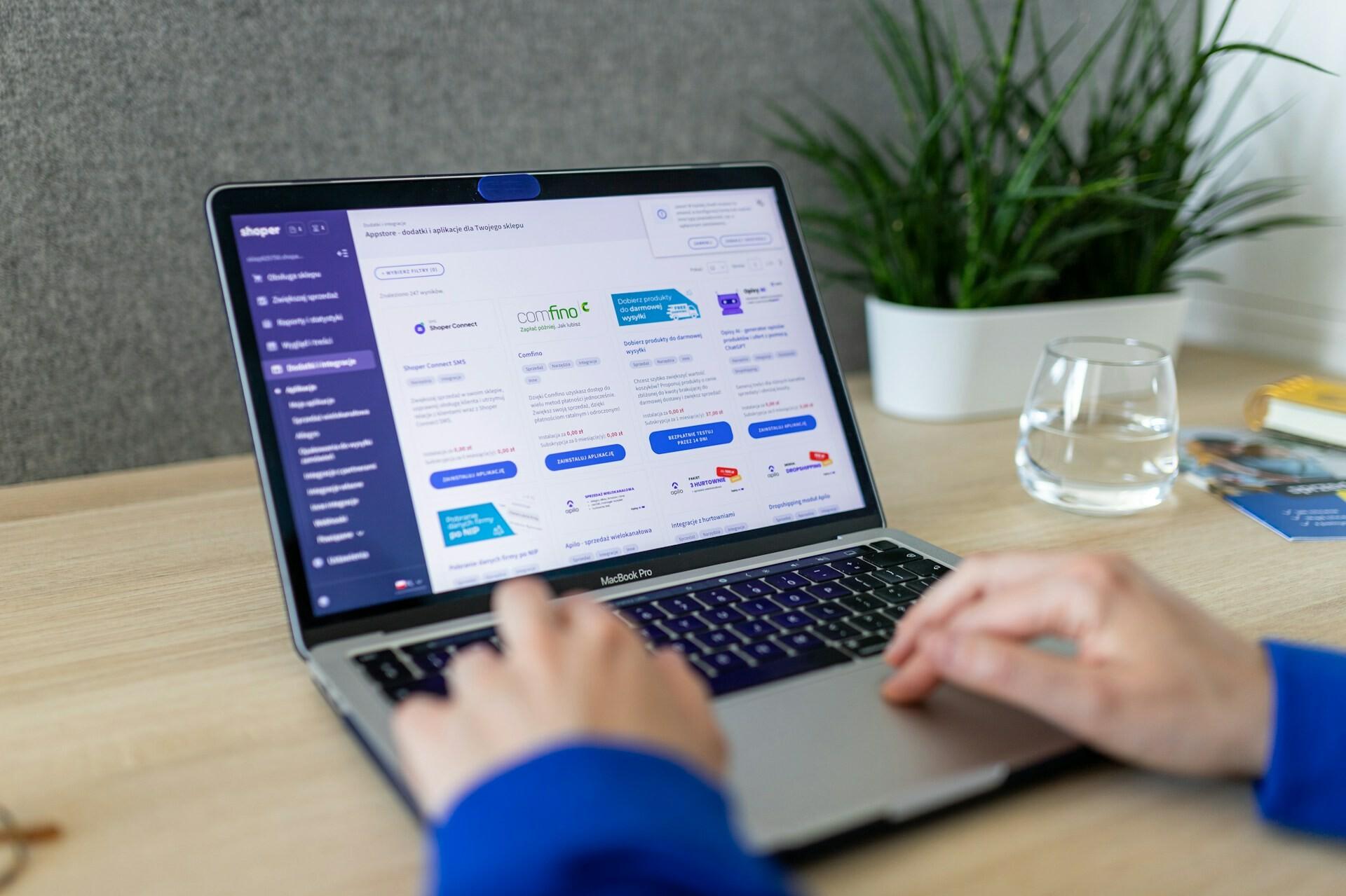 Bildschirm mit Store Two hands are typing on a laptop and an online shop can be seen on the screen.