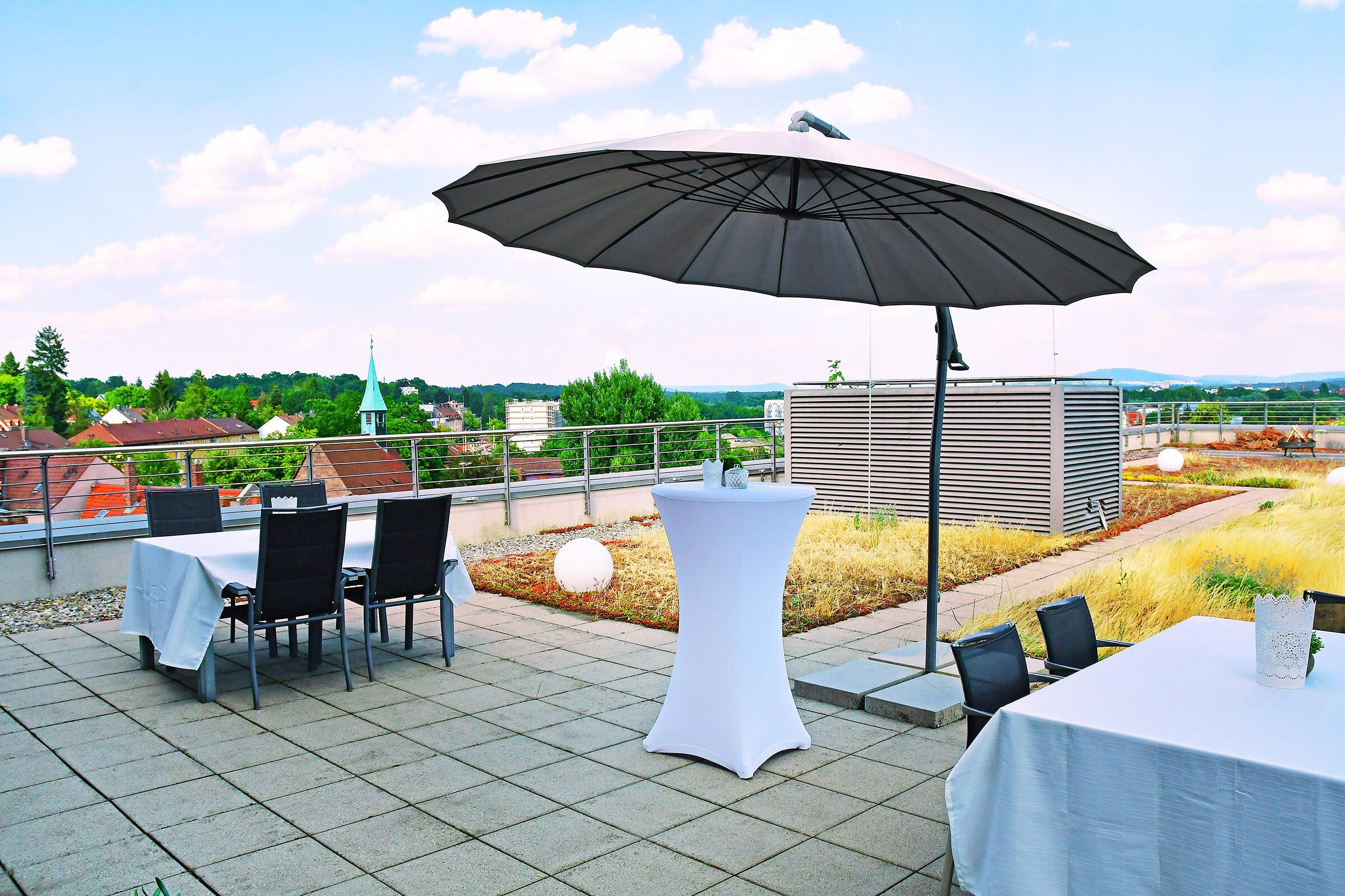 Tische und Sonnensegel auf der Dachterrasse