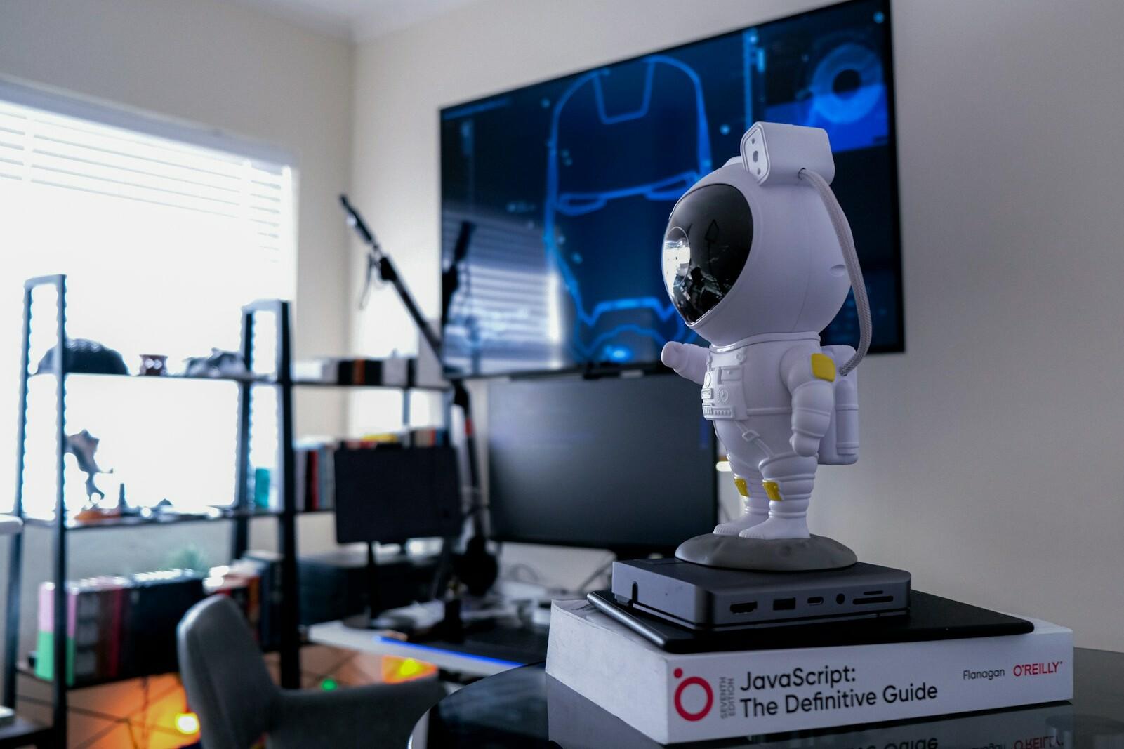 Büro mit Roboter auf einem Schreibtisch A robot stands on a pile of books on a desk in an office.