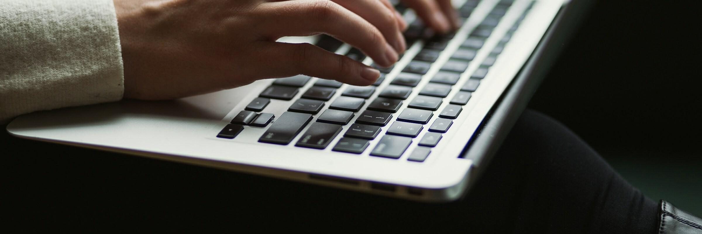 Finger auf Laptop Hände an einer Tastatur